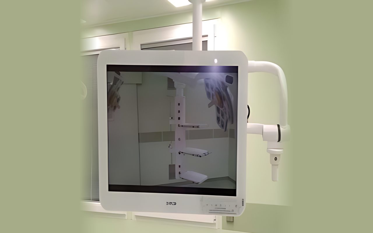 Medical-grade display on a white ceiling arm in a hospital room