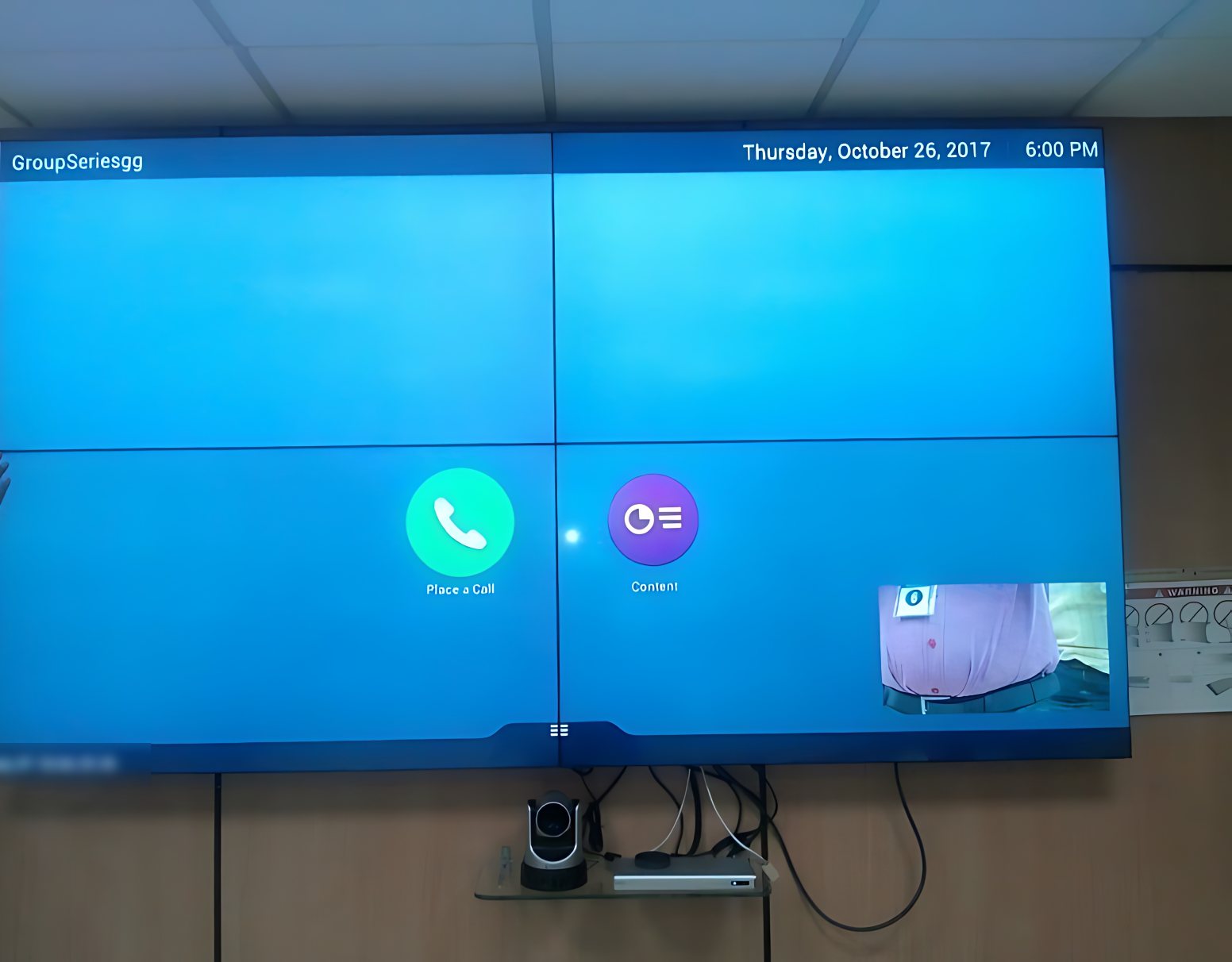 2 by 2 video wall showing a video conferencing home screen, with a camera on a shelf below